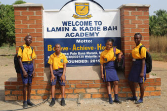 Students stand outside The Lamin & Kadie Bah Academy